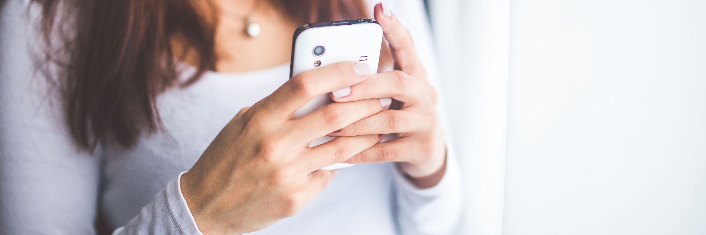 Woman holding a cell phone texting