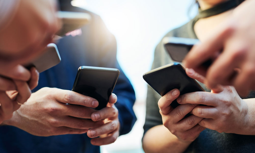 a photo image of several pairs of hands holding cell phones