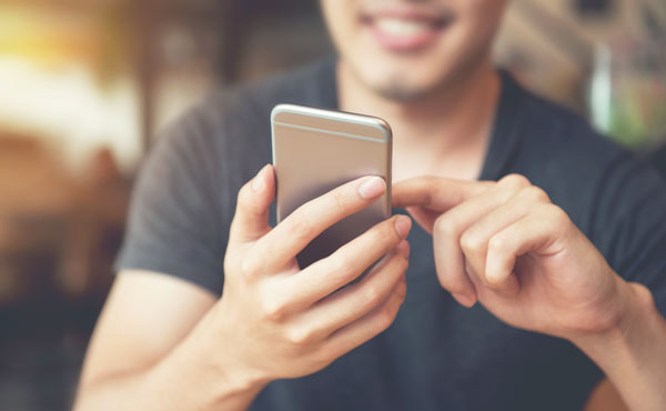 Photograph of man looking at his smartphone accessing the directory.